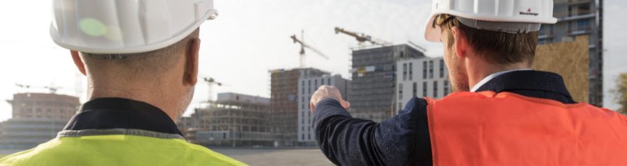 Businessman and architect talking about new building projects at a construction site